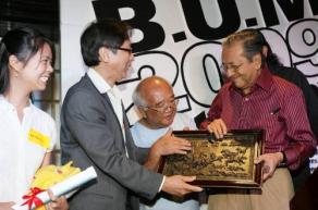 政策倡議中心主任林德宜博士（左2）贈送紀念品給馬哈迪（右）。右2：政策倡議中心編輯鍾仁隆。（圖：星洲日報）